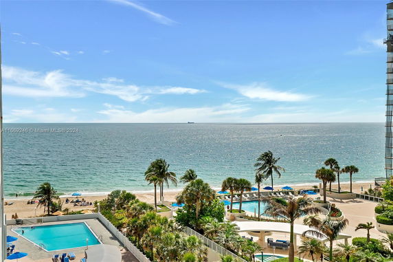 View of a beachfront area with palm trees and the ocean.