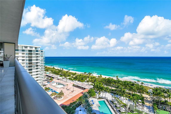 Panoramic view from a building overlooking the ocean and nearby buildings.