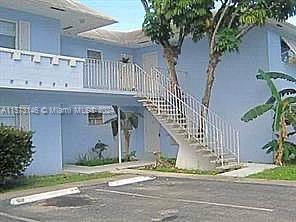 Front view of a two-story building with an exterior staircase.