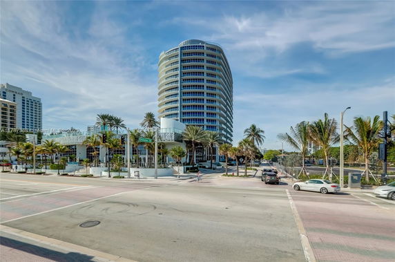Front view of a multi-story modern building with cylindrical architecture.