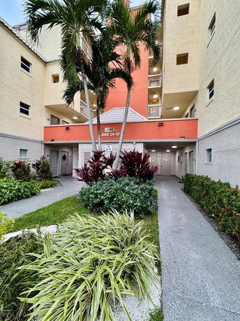 Front view of a multi-story building with balconies and landscaping.