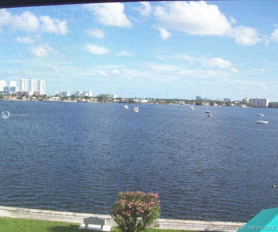 View of a body of water with boats and distant buildings.