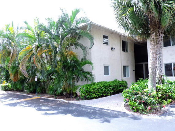 Front view of a multi-story building with surrounding greenery.