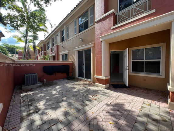 Front view of a two-story townhouse with an open patio area.