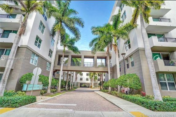 Front view of a multi-story residential building with connecting walkway.