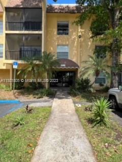 Front view of a multi-story residential building with balconies and an entrance canopy.