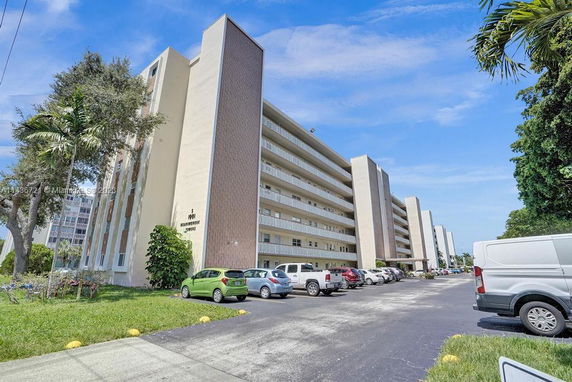 Front view of a multi-story apartment building with balconies.