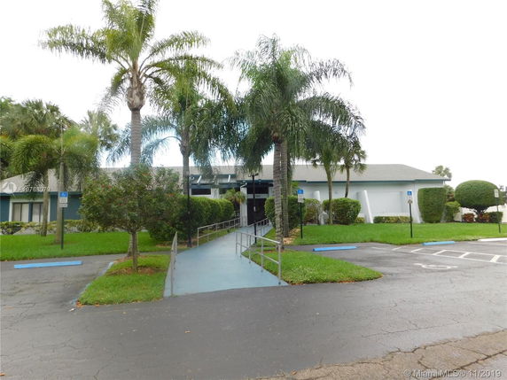 Front view of a single-story building with a ramp and wheelchair accessible parking.