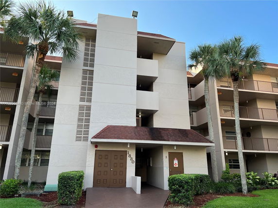 Front view of a multi-story building with a central entrance and balconies.