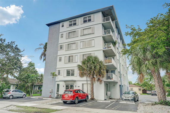 Front view of a multi-story apartment building with balconies.