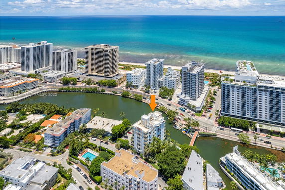 Aerial view of coastal buildings near a beach and waterway.