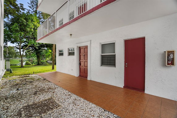 View of a building entrance with two doors and a garden area.