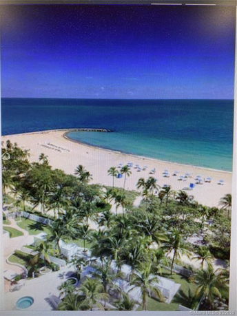 Panoramic view of a tropical beach with palm trees and ocean.