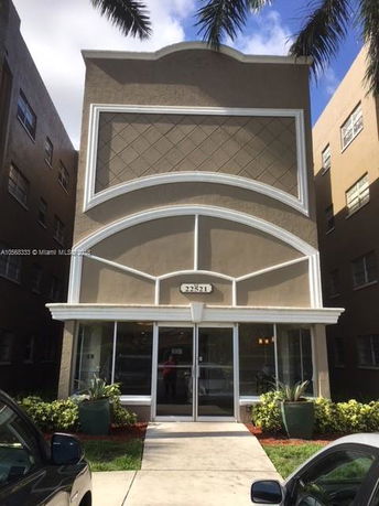 Front view of a multi-story residential building with decorative arched features.