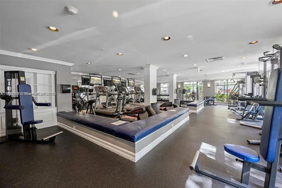 Indoor gym area with various exercise equipment and large windows.