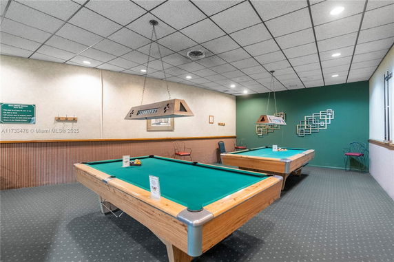Recreation room with billiards tables and seating.