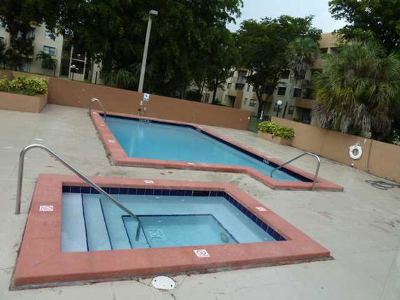 Outdoor area with a swimming pool and a smaller pool.