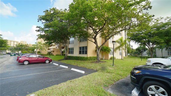Outdoor parking area next to a multi-story residential building.
