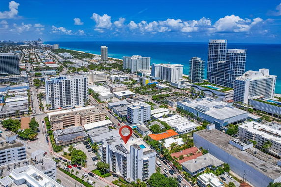Aerial view of a coastal cityscape with high-rise buildings and the ocean in the background.