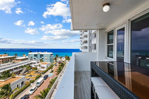 Balcony view overlooking residential buildings and the ocean.