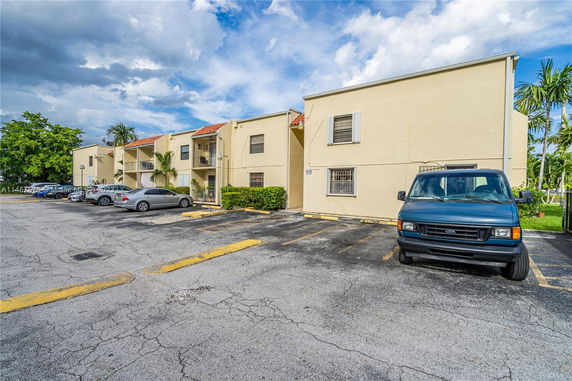 Outdoor parking area in front of a two-story building.