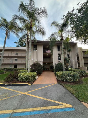 Front view of a multi-story residential building with a sidewalk entrance.