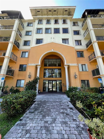 Front view of a multi-story building with an arched entrance.