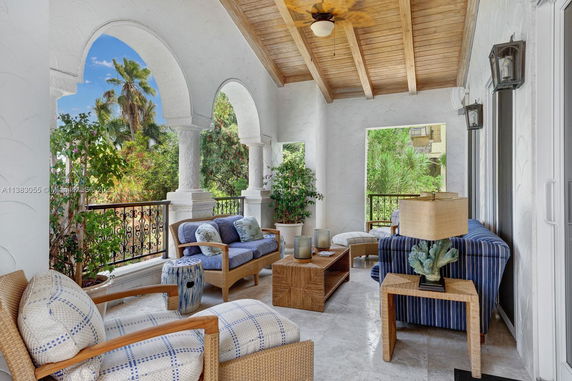 Outdoor patio area with arched openings and comfortable seating.