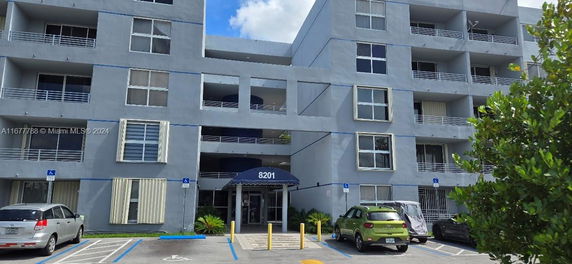 Front view of a multi-story apartment building with balconies.