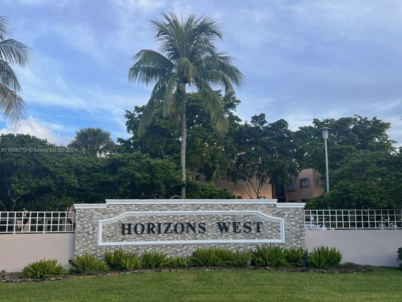 Front view of a building entrance sign reading 'Horizons West' with surrounding greenery.