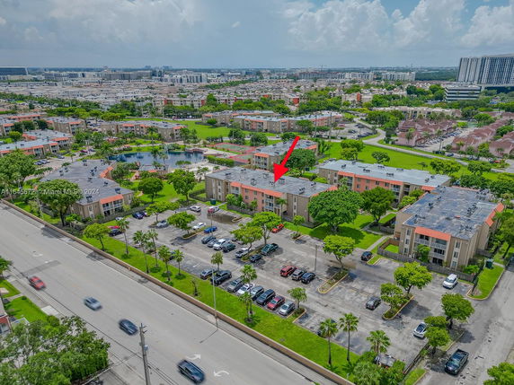 Aerial view of a residential area with multiple apartment buildings and parking spaces.