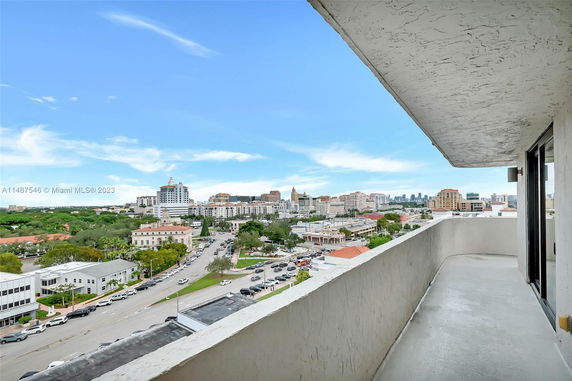View from a balcony overlooking a cityscape with buildings and roads.