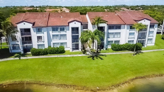 Front view of a three-story apartment building with red tile roofs.
