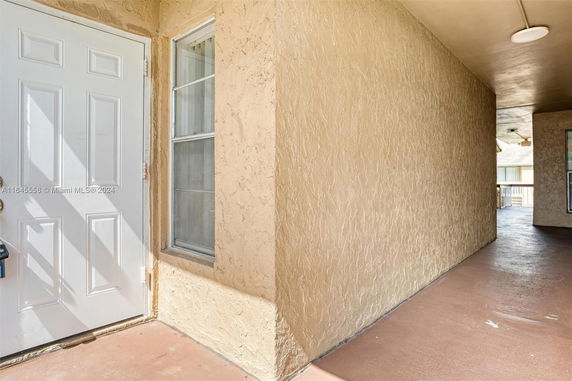 Exterior view of a building with a textured wall and a white door.