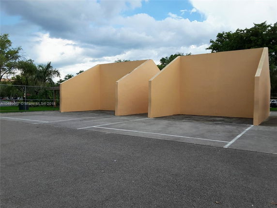 Outdoor play area with two wall structures for sports activities.