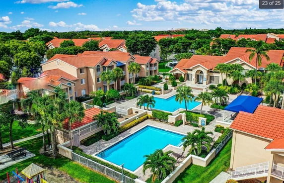 Outdoor view of buildings with multiple swimming pools and surrounding greenery.