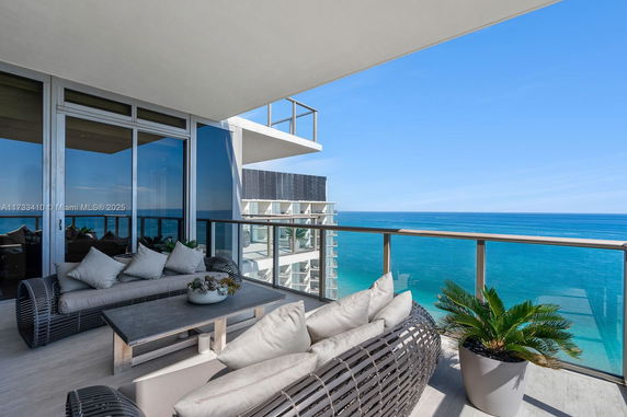 Balcony with ocean view and outdoor seating area.