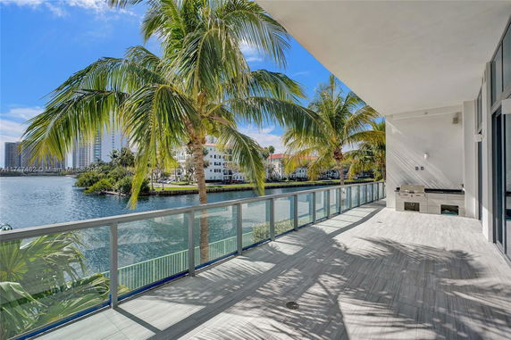 View from a balcony overlooking palm trees and water.