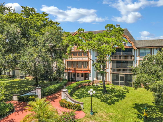 Front view of a multi-story building with Tudor-style architecture and landscaped garden.