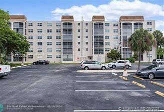 Front view of a multi-story residential building with parking area.