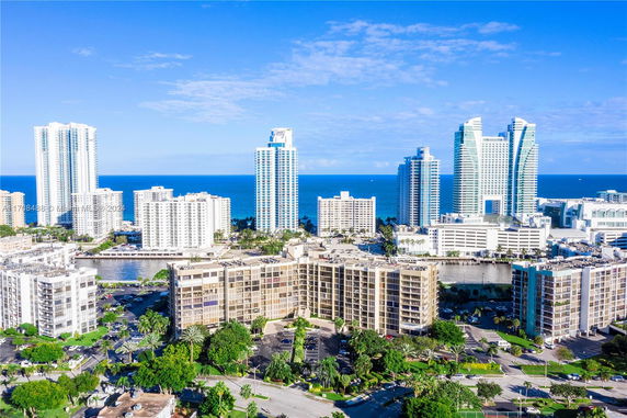 Aerial view of high-rise buildings near the coastline with a view of the ocean in the background.