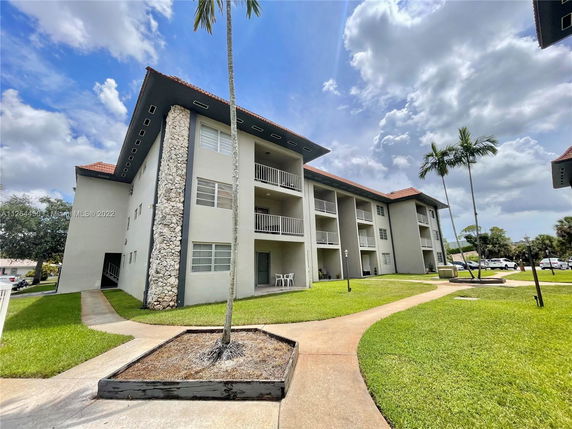 Front view of a three-story apartment building with balconies.