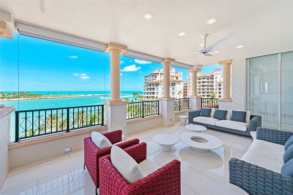 Luxury balcony with modern seating and panoramic ocean view.