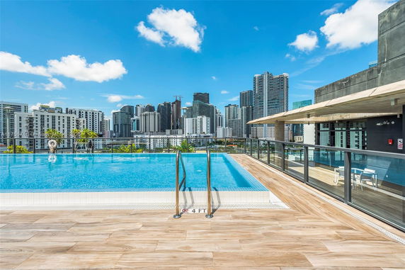 Rooftop swimming pool with city skyline in the background.