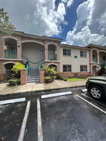 Front view of a two-story residential building with parking spaces.