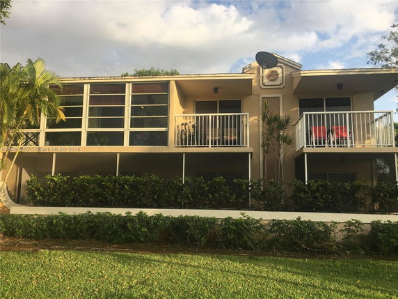 Front view of a two-story building with balconies and large windows.