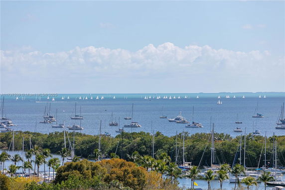 Wide view of a marina with numerous boats and sailboats on the water.