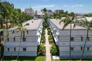 Aerial view of two adjacent multi-story residential buildings with a path and landscaping between them in an urban setting.