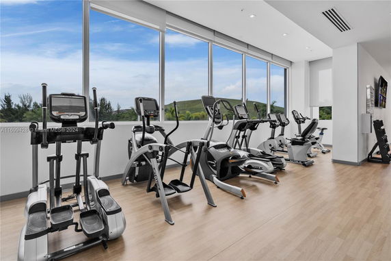 Indoor gym area with exercise equipment and large windows.