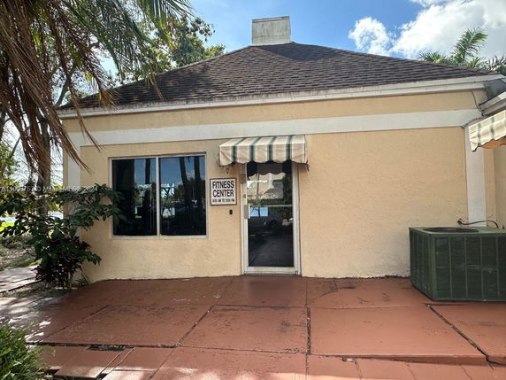 Front view of a building labeled Fitness Center with an awning and air conditioning unit.